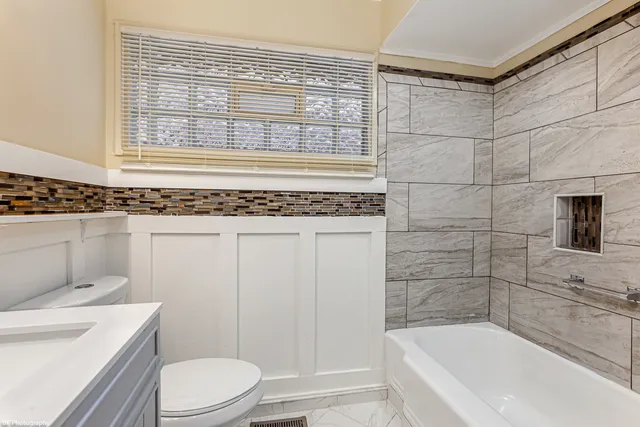 a bathroom with a granite countertop toilet a sink and bathtub