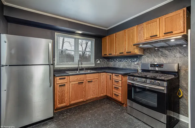 a kitchen with stainless steel appliances granite countertop a stove a refrigerator and a microwave