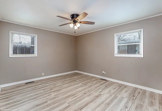 a view of empty room with wooden floor