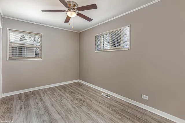 a view of empty room with wooden floor