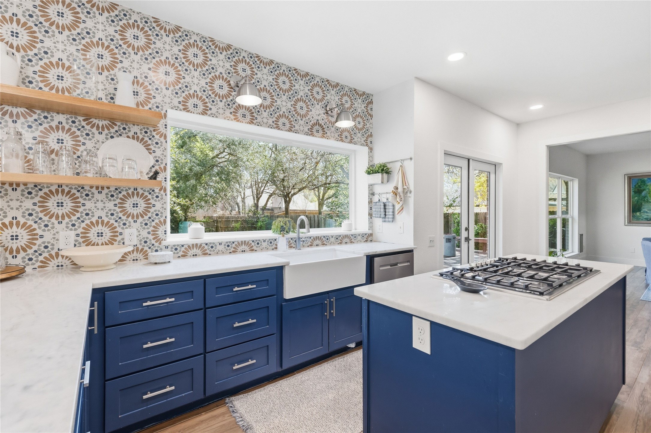 6310 Walebridge Lane Austin, TX 78739 - Photo 12 of 40 Kitchen with blue cabinets, light stone counters, light wood finished floors, healthy amount of natural light, and recessed lighting