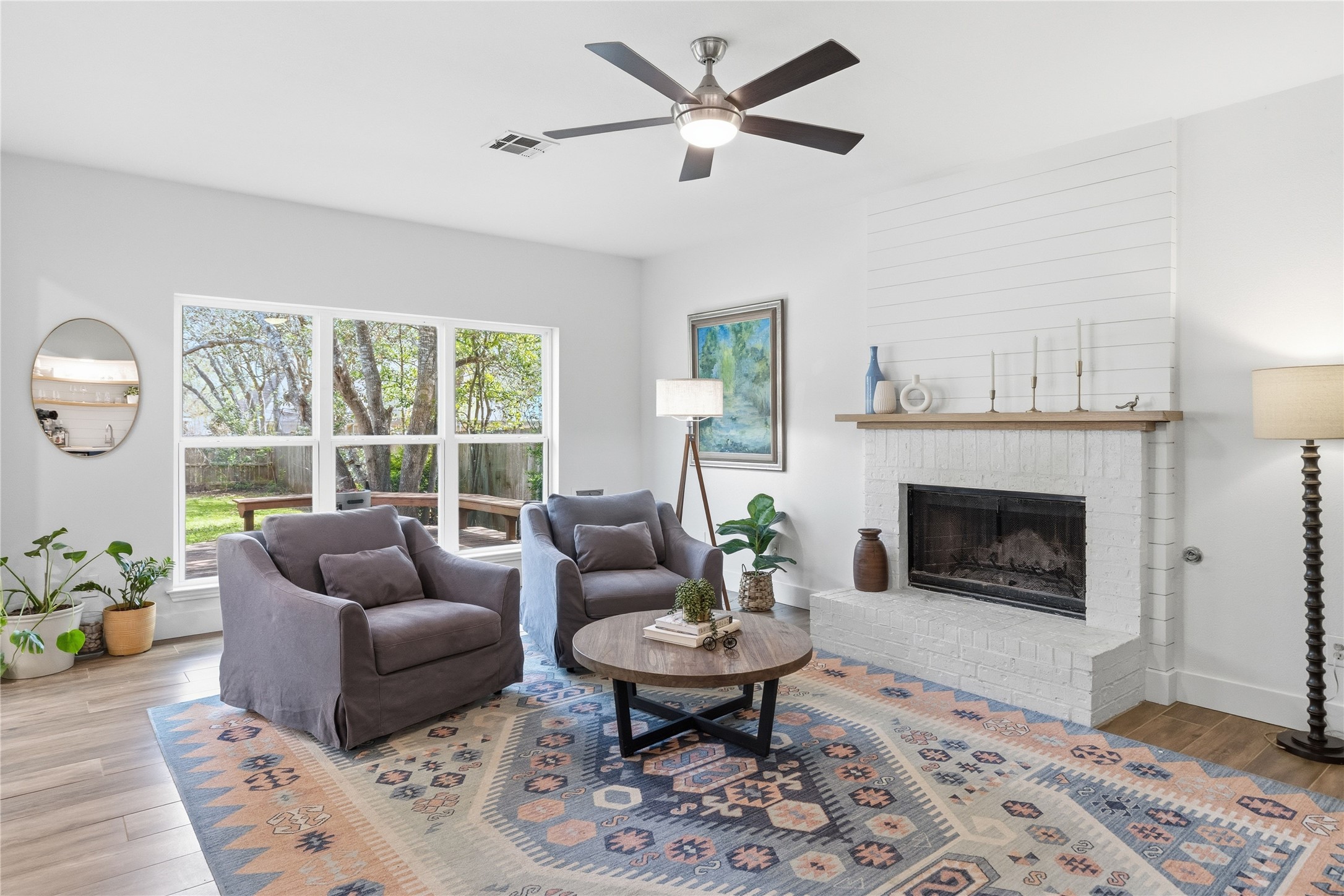 6310 Walebridge Lane Austin, TX 78739 - Photo 18 of 40 Living area featuring light wood-style flooring, a ceiling fan, and a fireplace