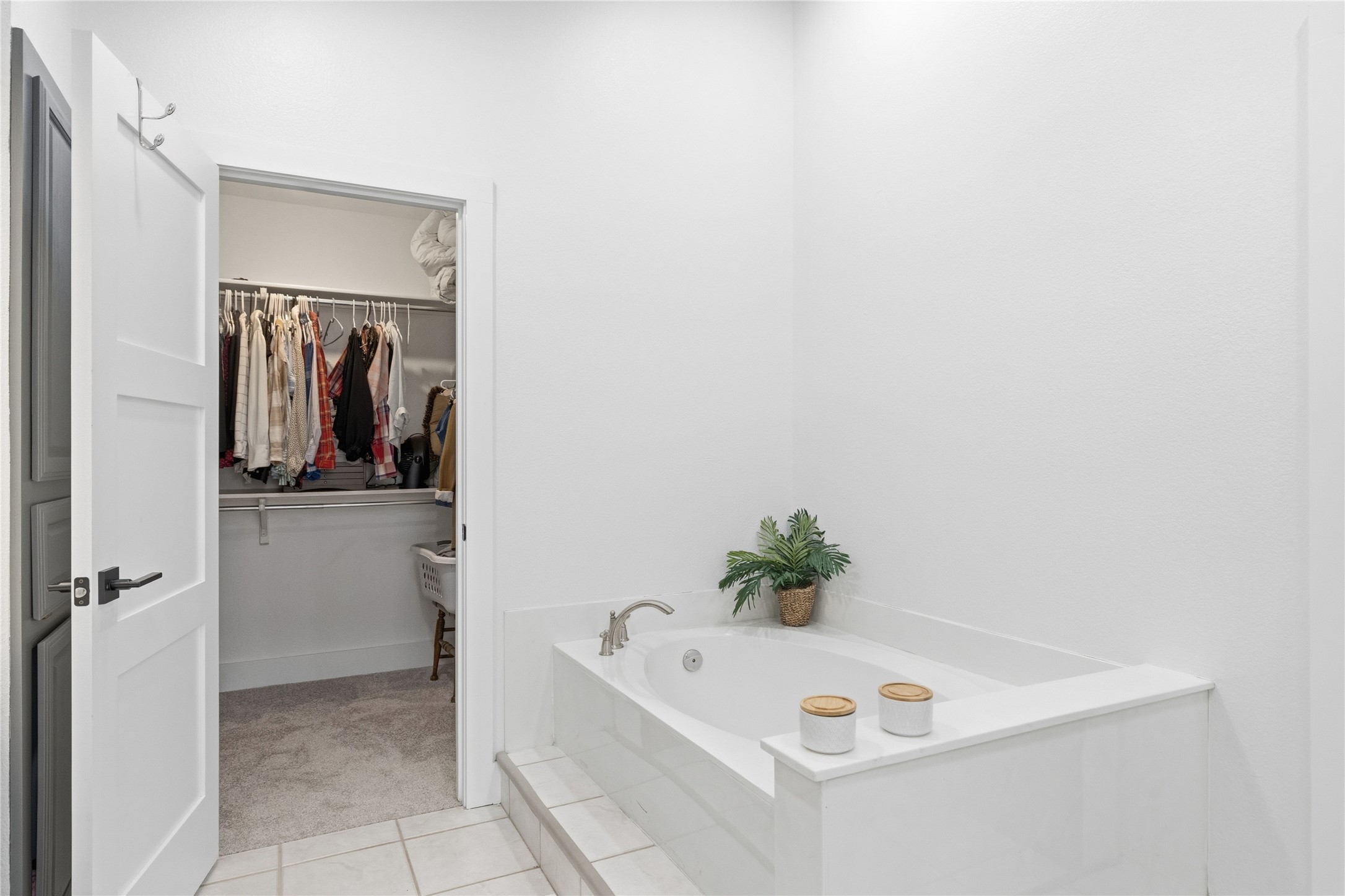 6310 Walebridge Lane Austin, TX 78739 - Photo 29 of 40 Full bathroom featuring a walk in closet, a garden tub, light colored carpet, and light tile patterned floors