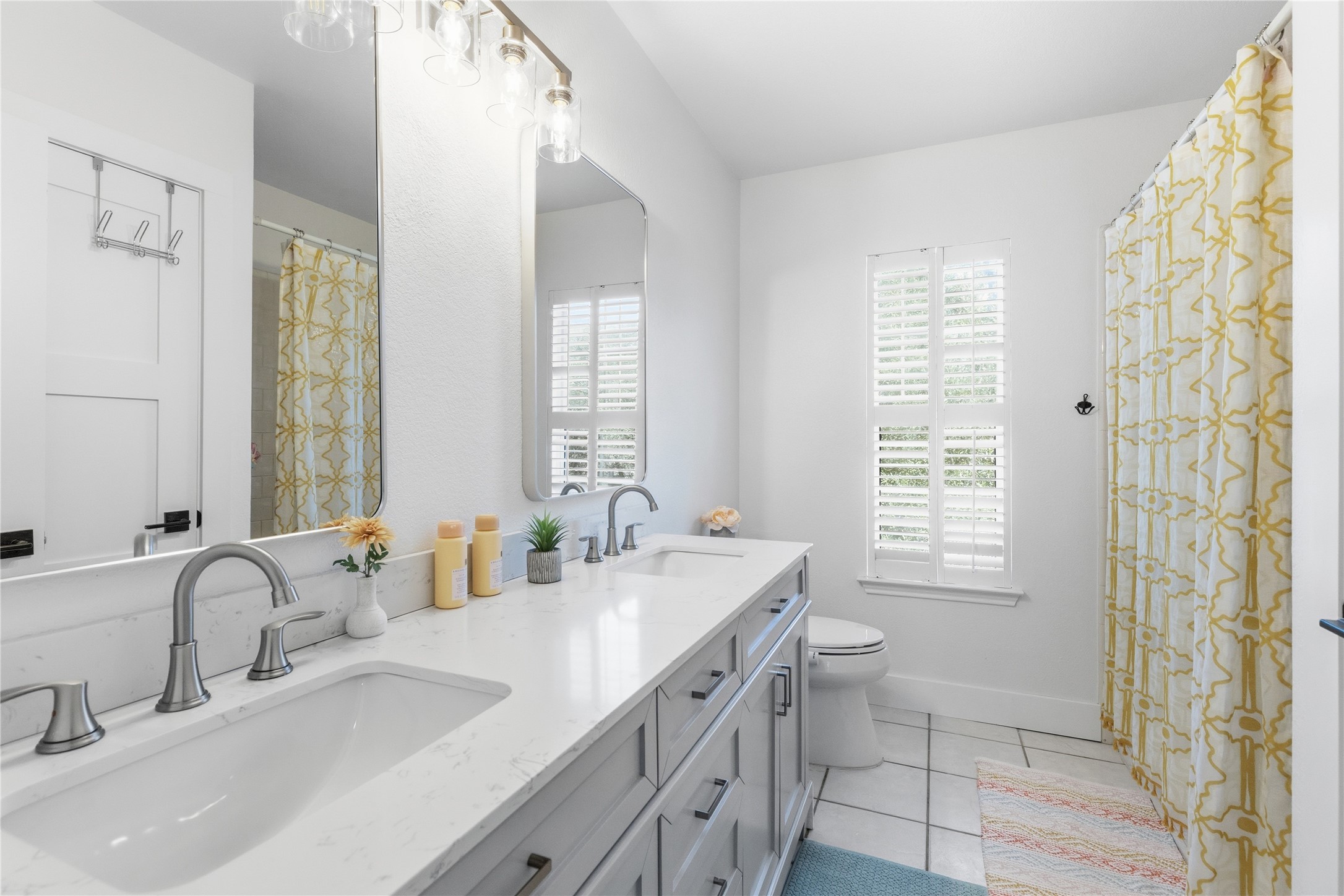 6310 Walebridge Lane Austin, TX 78739 - Photo 34 of 40 Bathroom featuring a shower with curtain, double vanity, and light tile patterned floors