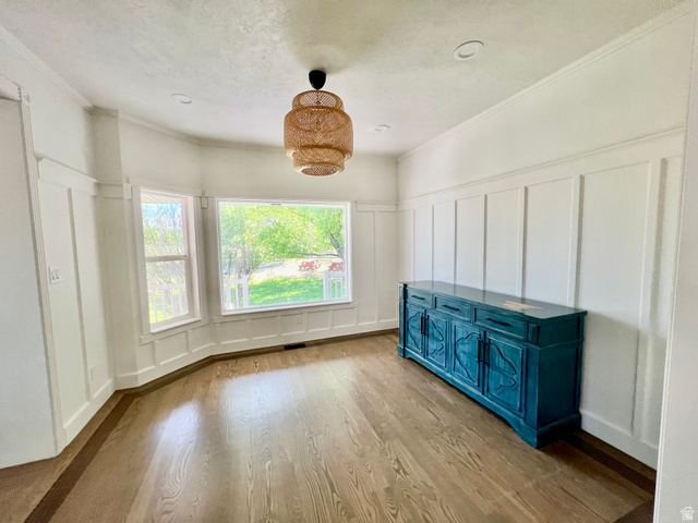 812 East Bates Cyn Road Tooele, UT 84074 - Photo 15 of 144 Dining area featuring natural wood-finish flooring with a contrasting border, board and batten wall detailing, and a multi-pane bay window