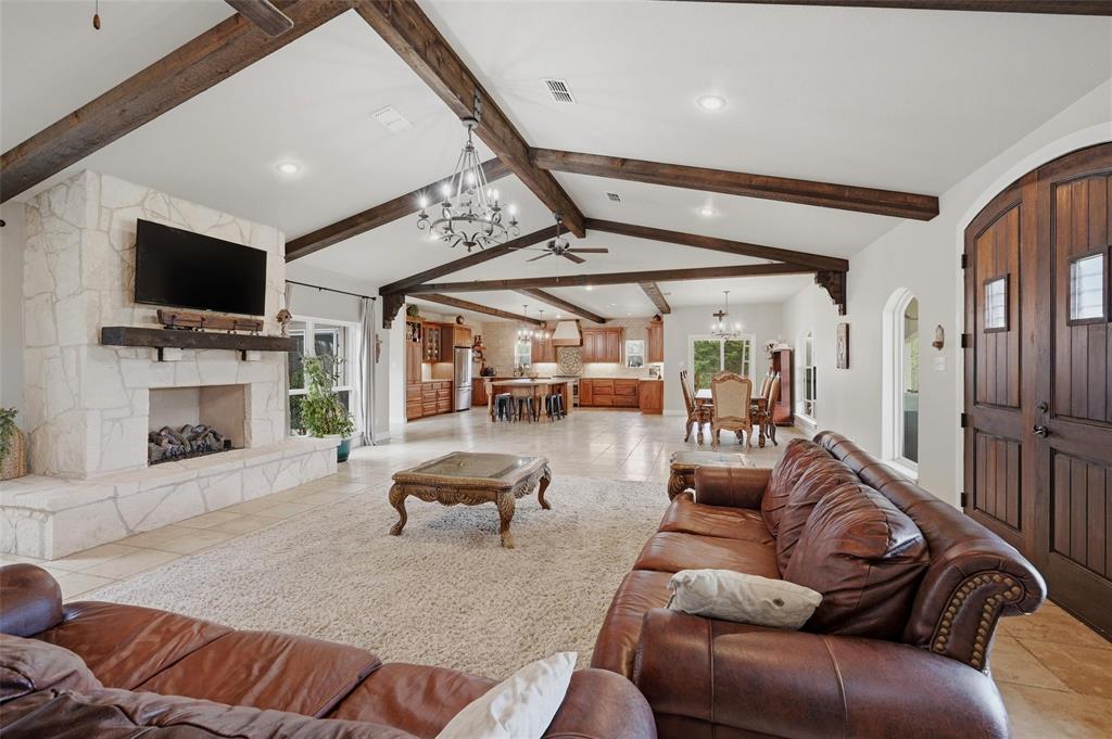 1959 Marlow Road Bells, TX 75414 - Photo 6 of 33 Living area with a large fireplace, plenty of natural light, suspended lighting, and beamed ceiling