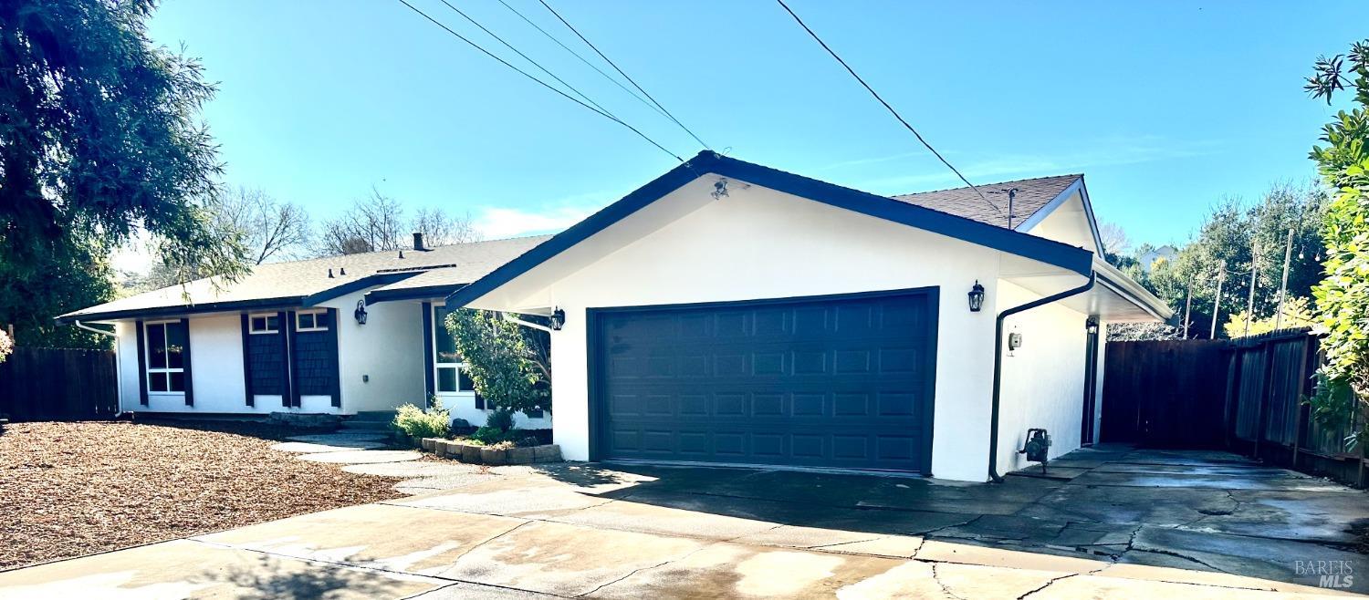a view of house with a yard and garage