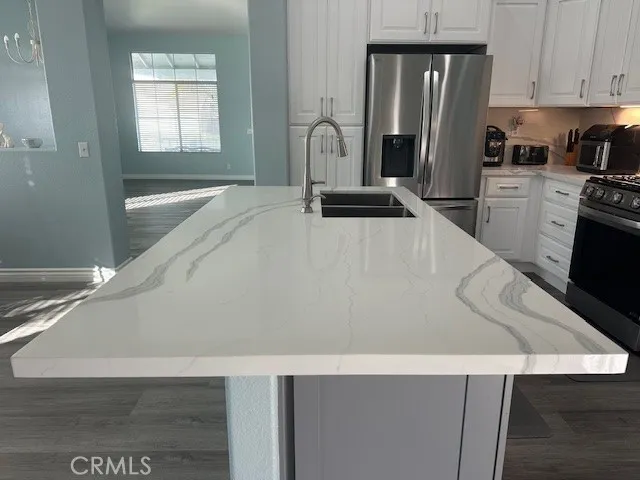a kitchen with white cabinets and black appliances