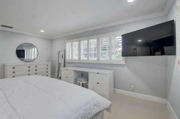 a bedroom with a bed and a large window