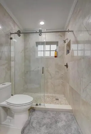 a bathroom with a shower a toilet and sink