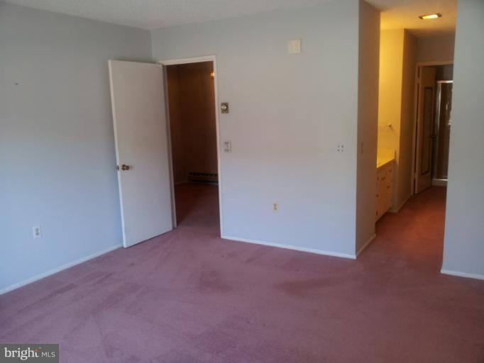 15100 Glade Drive, Unit 112E Silver Spring, MD 20906 - Photo 11 of 25 an empty room with closet and a hallway