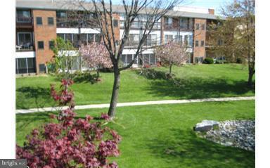 15100 Glade Drive, Unit 112E Silver Spring, MD 20906 - Photo 13 of 25 a front view of a house with a yard and a fountain