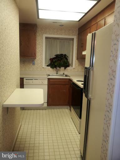 15100 Glade Drive, Unit 112E Silver Spring, MD 20906 - Photo 8 of 25 a kitchen with stainless steel appliances a sink stove and refrigerator