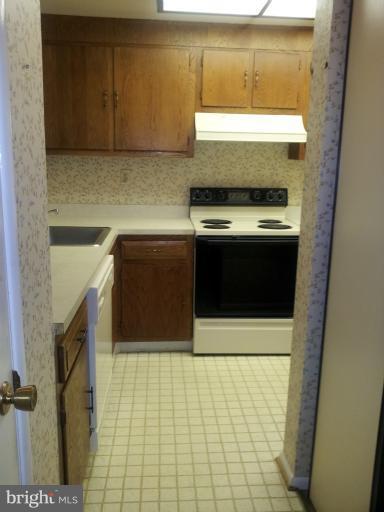 15100 Glade Drive, Unit 112E Silver Spring, MD 20906 - Photo 10 of 25 a kitchen with a stove and a microwave
