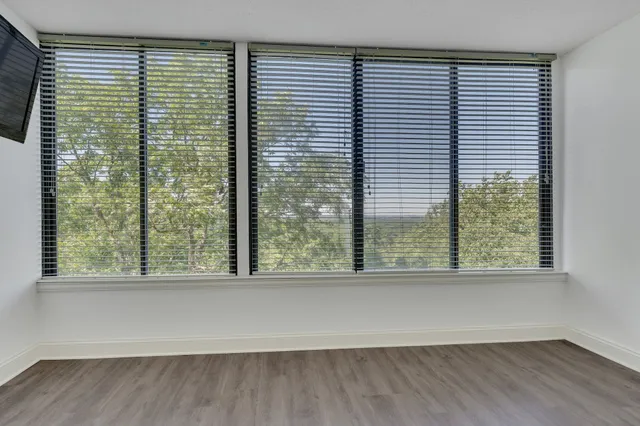 a living room with furniture a flat screen tv and large window