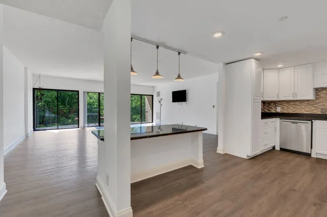 a kitchen with granite countertop a sink stainless steel appliances and cabinets