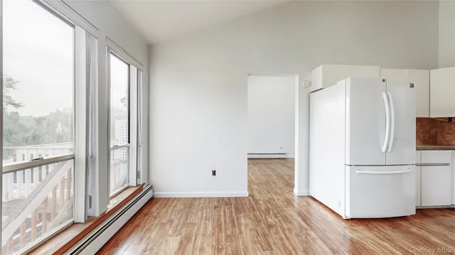 a view of a kitchen with wooden floor and electronic appliances