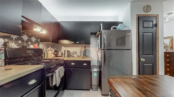 a kitchen with stainless steel appliances granite countertop a refrigerator a sink and a stove