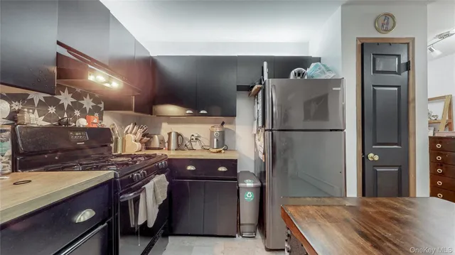 a kitchen with stainless steel appliances granite countertop a refrigerator a sink and a stove