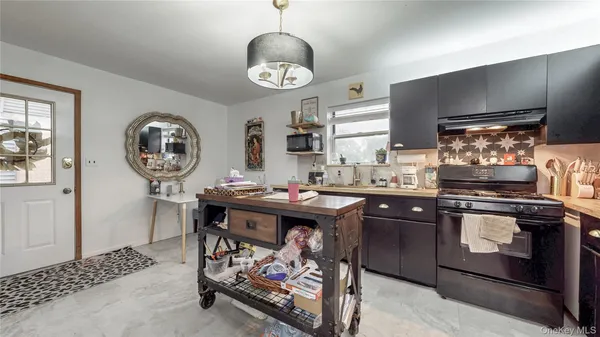 a kitchen with a sink a stove cabinets and stainless steel appliances