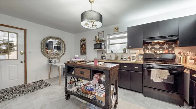 a kitchen with a sink a stove cabinets and stainless steel appliances
