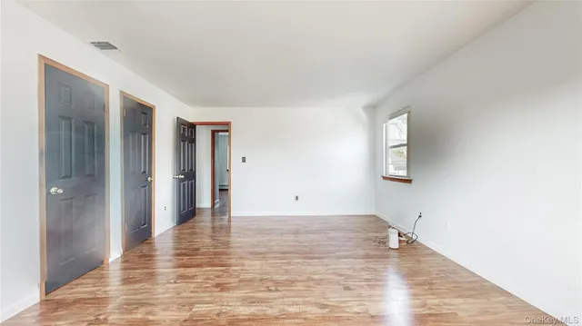 a view of an empty room with closet and a window