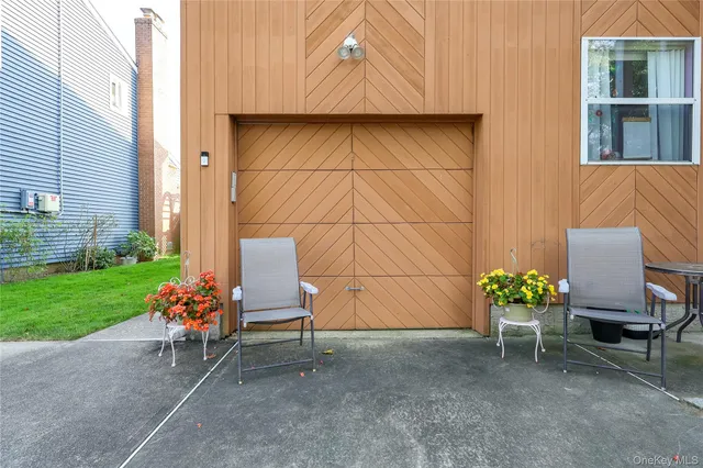 a view of a chair and table in the back yard of the house