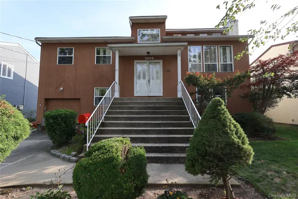a front view of a house with plants