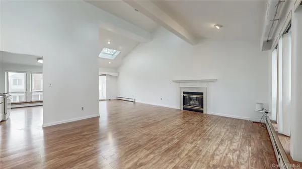 an empty room with wooden floor and fireplace