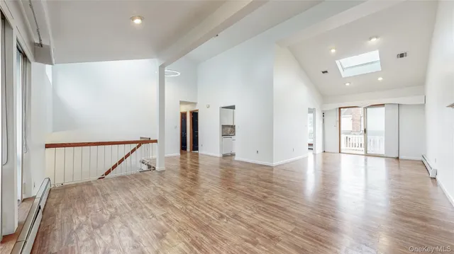 a view of a livingroom with wooden floor and staircase
