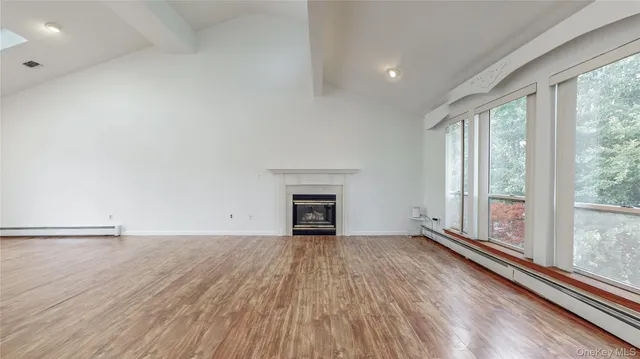 wooden floor fireplace and windows in an empty room