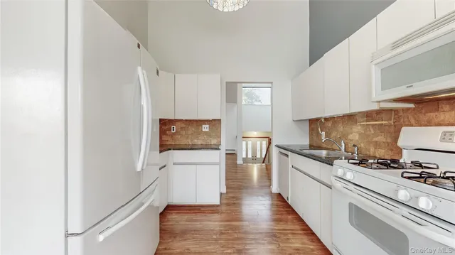 a kitchen with white cabinets and appliances
