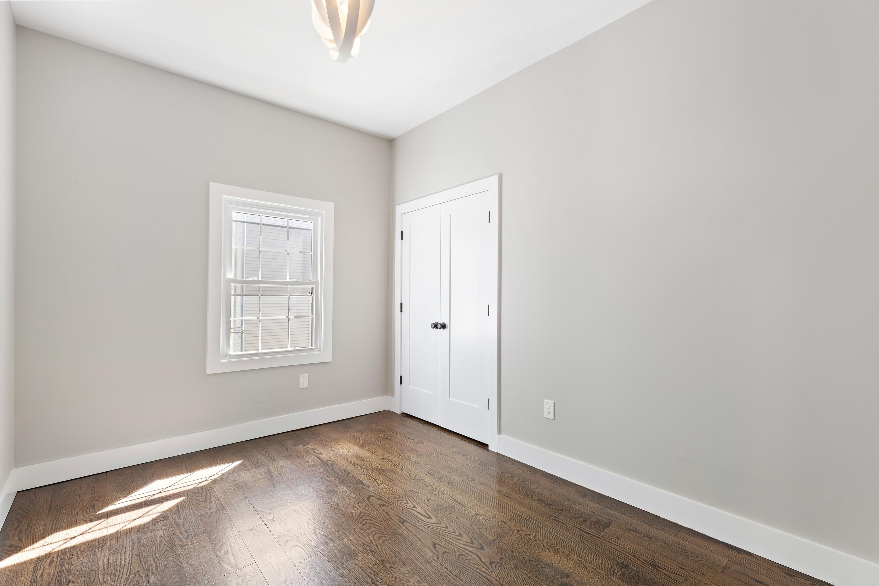 189 Hackensack Plank Road Weehawken, NJ 07086 - Photo 18 of 46 an empty room with wooden floor and windows
