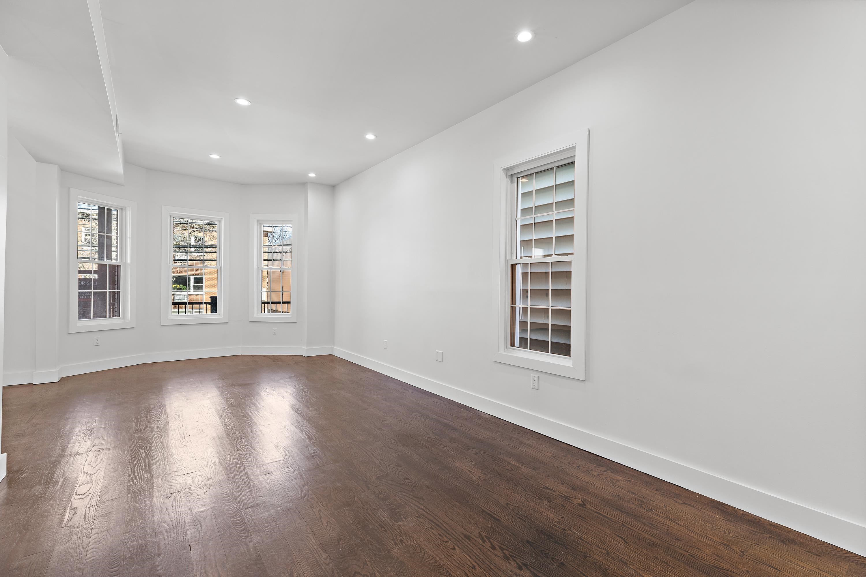 189 Hackensack Plank Road Weehawken, NJ 07086 - Photo 22 of 46 a view of an empty room with wooden floor and a window