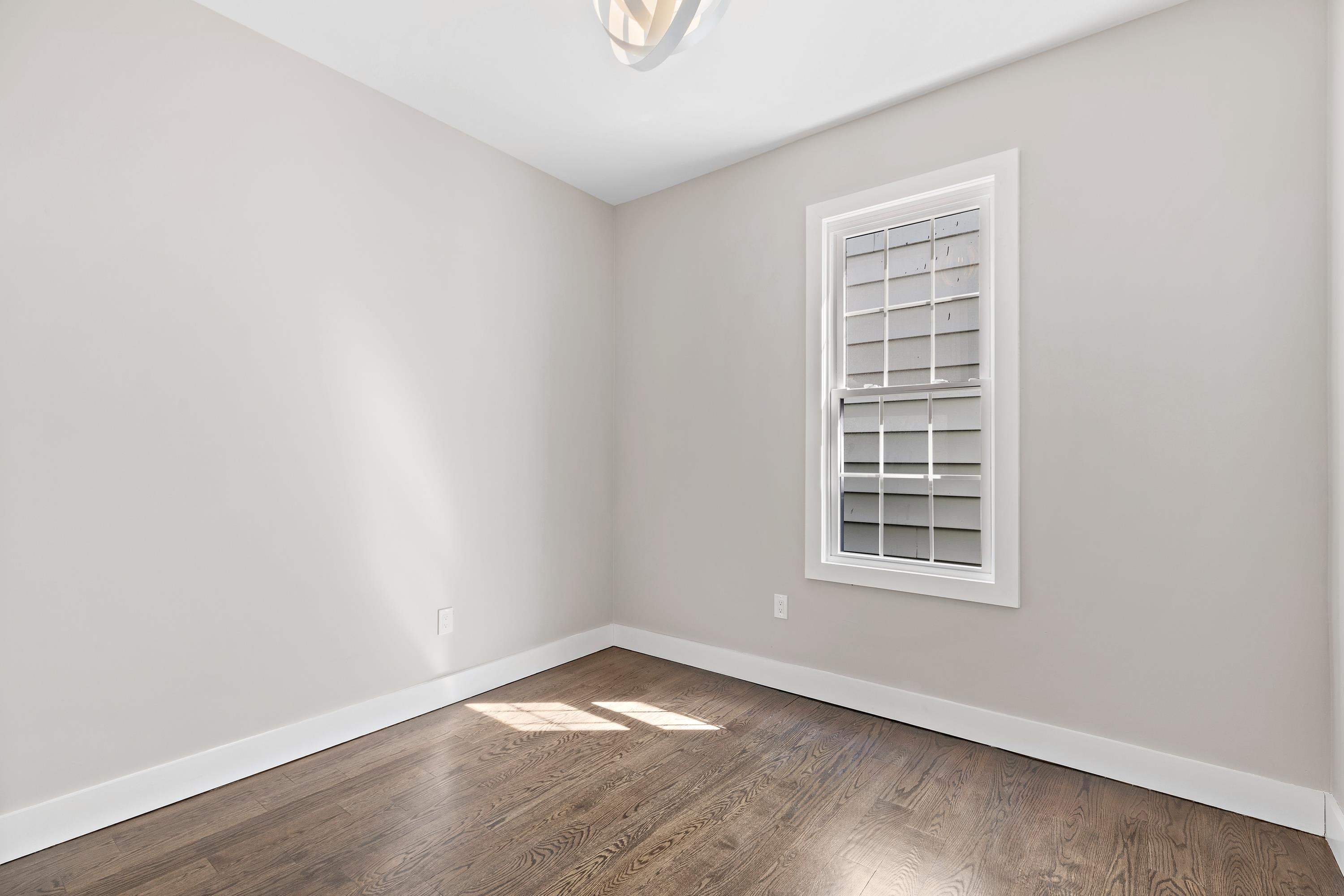 189 Hackensack Plank Road Weehawken, NJ 07086 - Photo 36 of 46 an empty room with wooden floor and windows