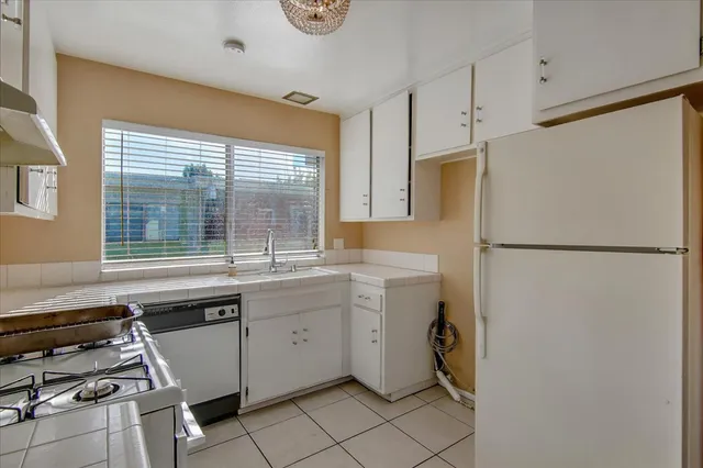 a kitchen with a sink a stove and cabinets