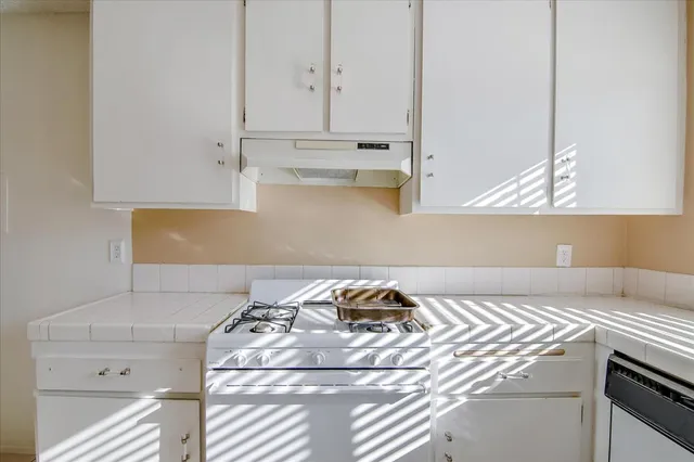 a kitchen with a sink stove and cabinets