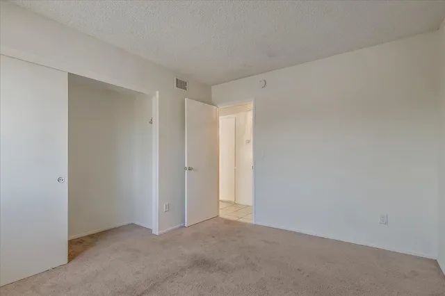 an empty room with windows and closet