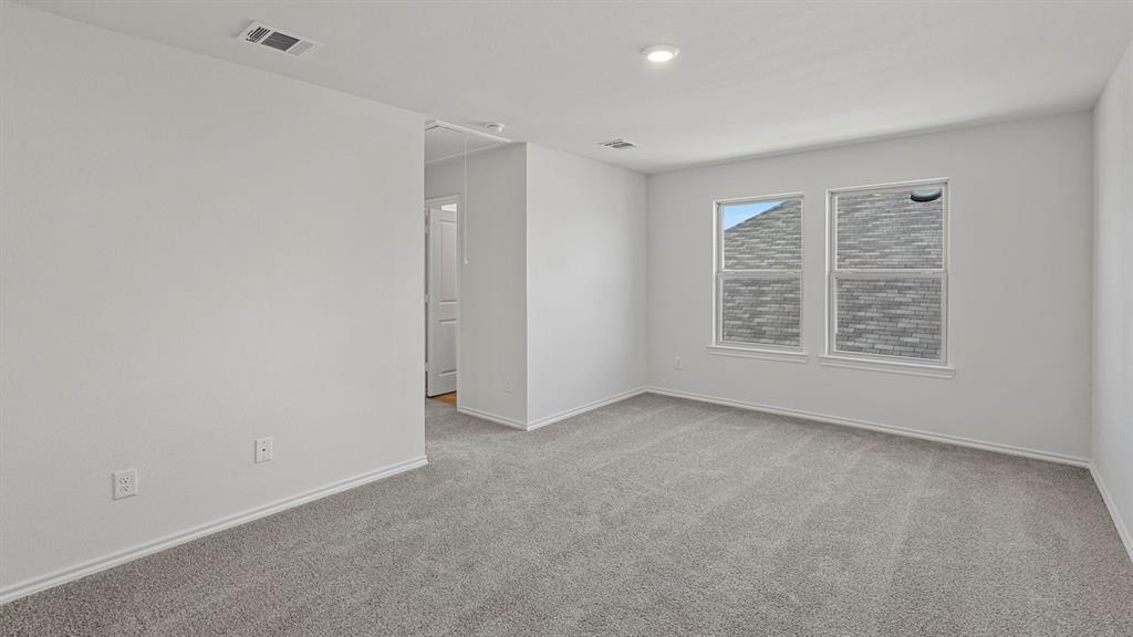 1627 Mantle Road Crandall, TX 75114 - Photo 14 of 40 Neutral gray carpeting with white trim, two double-hung windows, and ceiling-mounted lighting