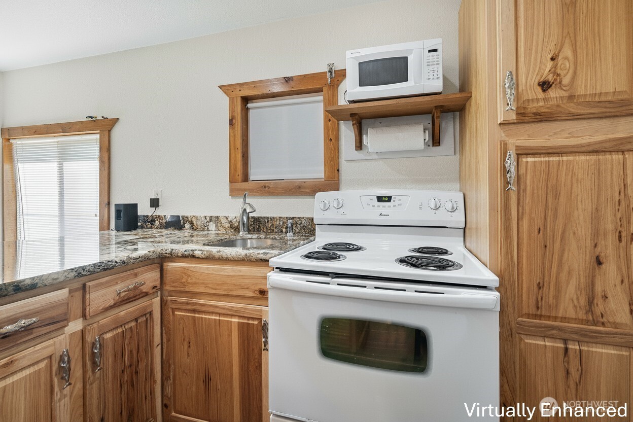 39217 Orville Road East Eatonville, WA 98328 - Photo 9 of 29 a kitchen with granite countertop a sink stove and cabinets
