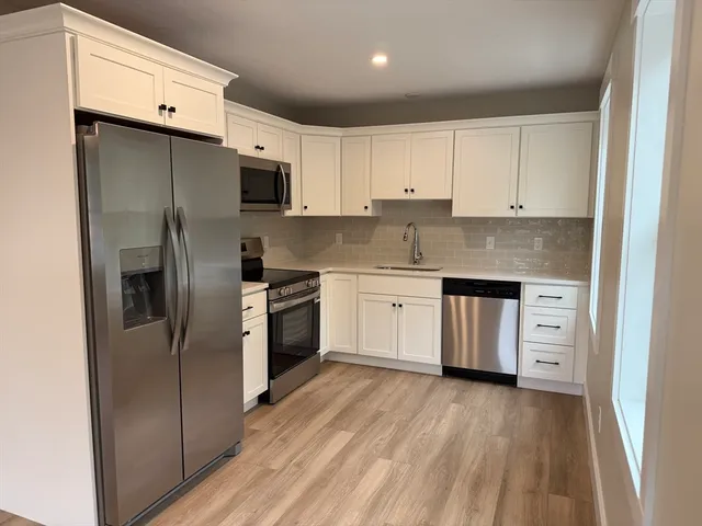 a kitchen with stainless steel appliances a refrigerator sink and cabinets