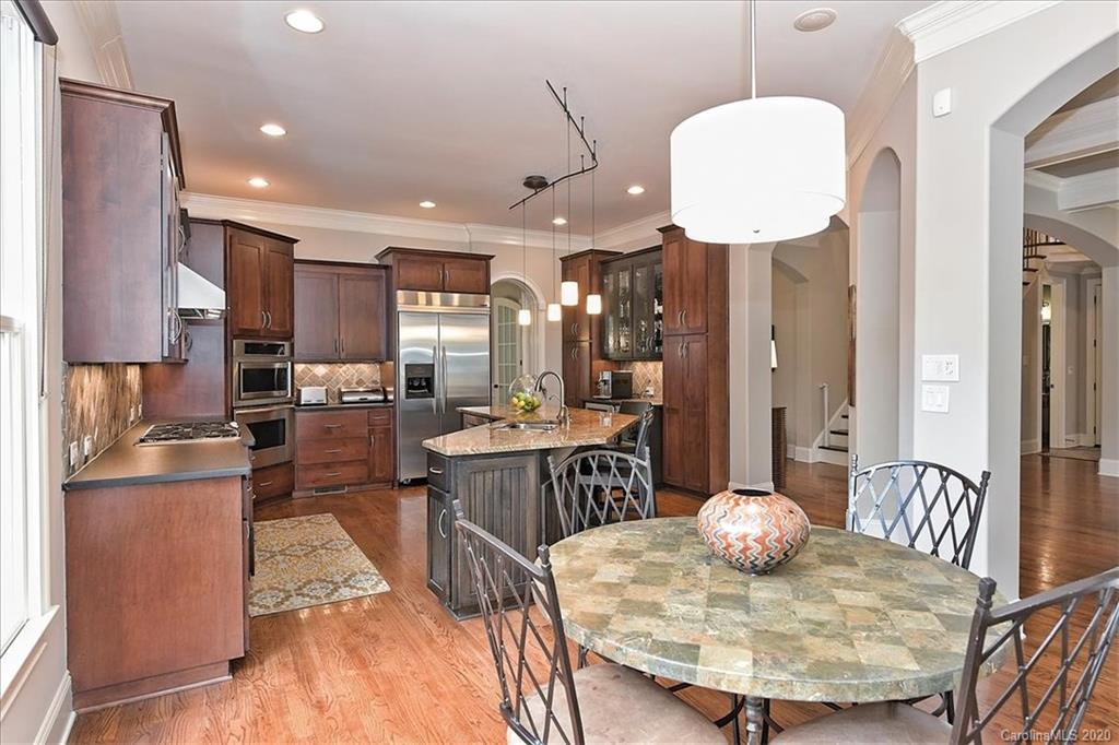 944 Bridlepath Lane Charlotte, NC 28211 - Photo 16 of 48 a kitchen with stainless steel appliances kitchen island granite countertop a table chairs and a refrigerator