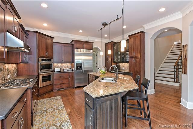 944 Bridlepath Lane Charlotte, NC 28211 - Photo 17 of 48 a kitchen with stainless steel appliances kitchen island granite countertop a refrigerator a stove a sink a oven with island and chairs