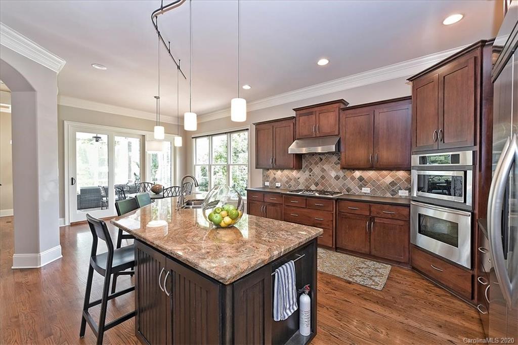 944 Bridlepath Lane Charlotte, NC 28211 - Photo 19 of 48 a kitchen with granite countertop kitchen island stainless steel appliances a sink a stove a table and chairs