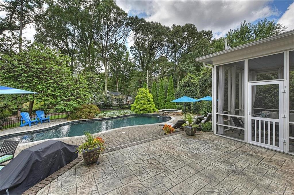 944 Bridlepath Lane Charlotte, NC 28211 - Photo 44 of 48 a backyard of a house with table and chairs under an umbrella