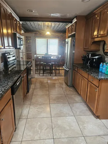 a kitchen with stainless steel appliances granite countertop a stove top oven a sink a counter space and cabinets