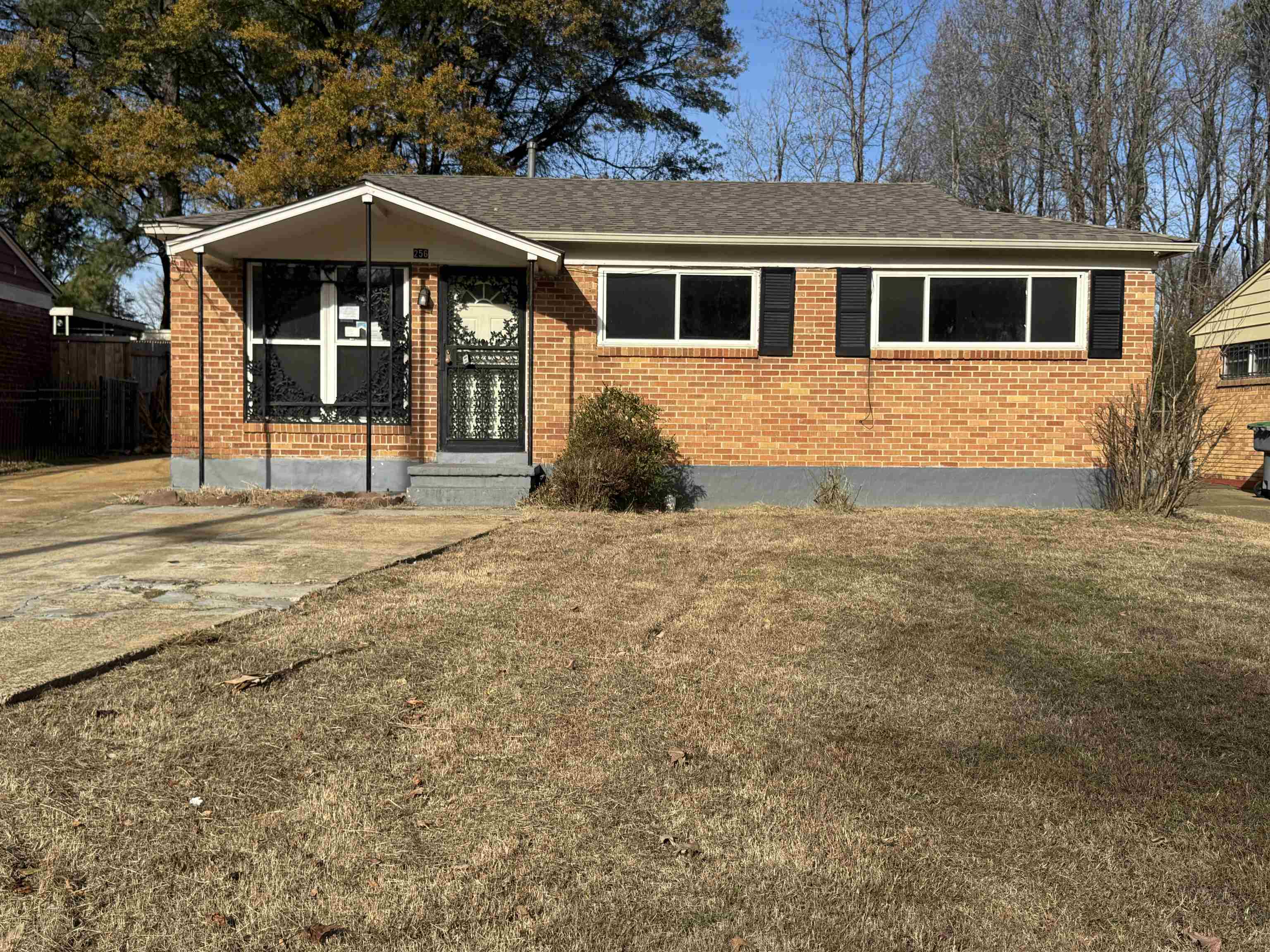 256 Delta Road Memphis, TN 38109 - Photo 2 of 22 View of front facade featuring brick siding, a front lawn, and a shingled roof