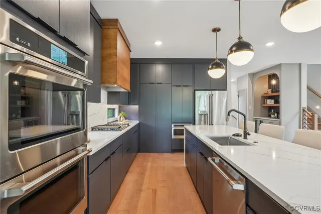 a large kitchen with stainless steel appliances a large counter space a sink and cabinets