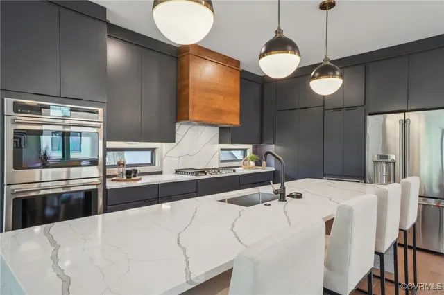 a kitchen with stainless steel appliances granite countertop a sink a stove and a refrigerator