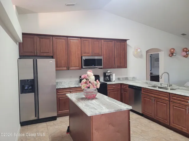 a kitchen with granite countertop a sink and cabinets